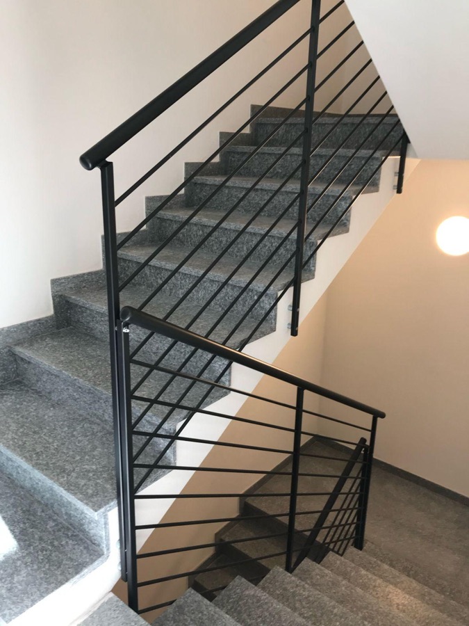 Ringhiera per scala interna a barre orizzontali con gradini in granito, a Levico Terme.
