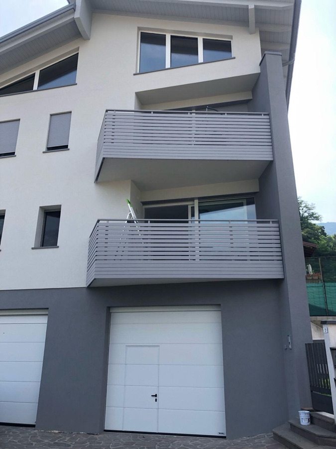 Parapetti per balconi a doghe orizzontali su una casa, a Lavis.